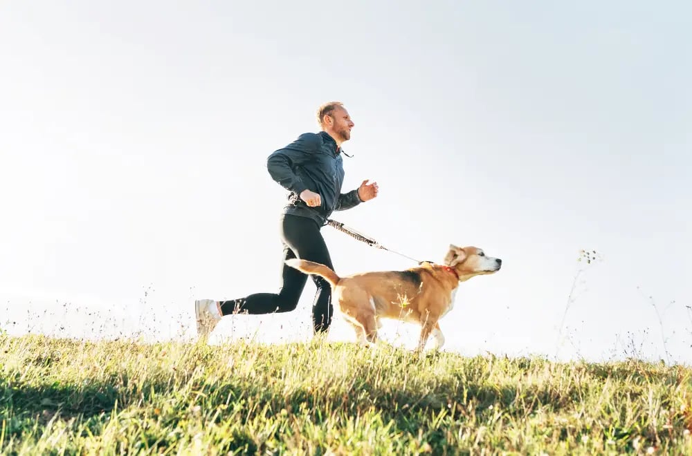 man-running-with-his-dog