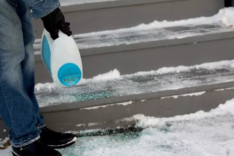 man-putting-down-ice-melt-on-steps